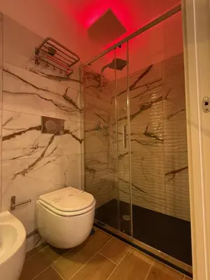a bathroom with a toilet and a glass shower at Dormire in Trastevere in Rome