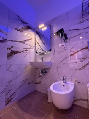 a white bathroom with a sink and a mirror at Dormire in Trastevere in Rome