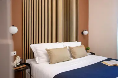 a bedroom with a bed with a striped wall at Porta Pia Stay GuestHouse in Rome