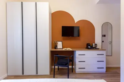 a bedroom with a desk with a tv and a heart wall at Porta Pia Stay GuestHouse in Rome