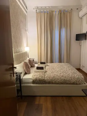 a bedroom with a bed and a window with curtains at Suncity Sweet Home in Rome
