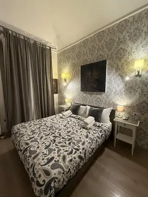 a bedroom with a large bed and two tables at Suncity Sweet Home in Rome