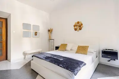 a white bedroom with a large white bed in it at Vatican Area Stylish 2BR Fast WiFi & AC in Rome