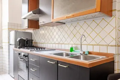 a kitchen with a sink and a stove at Vatican Area Stylish 2BR Fast WiFi & AC in Rome