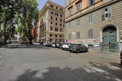 a city street with cars parked next to tall buildings at Castro Pretorio Sweet Home in Rome