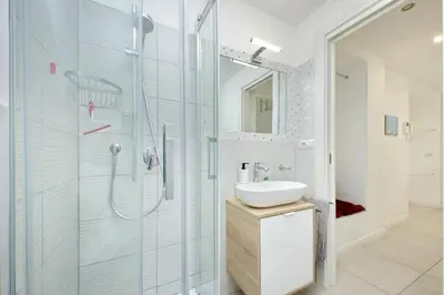 a bathroom with a glass shower and a sink at Castro Pretorio Sweet Home in Rome