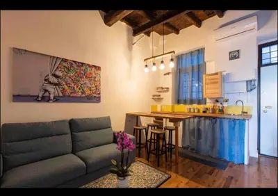 a living room with a couch and a kitchen at Home trastevere in Rome