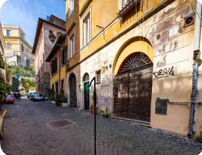 a cobblestone street in a city with a building at Home trastevere in Rome