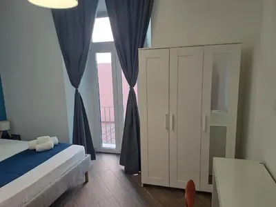 a bedroom with a bed and a large window at At Home Gaeta Guest House in Rome