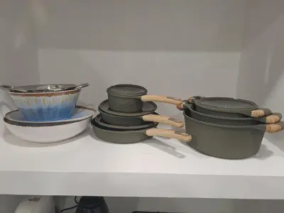 a shelf with four pots and pans and a bowl at At Home Gaeta Guest House in Rome