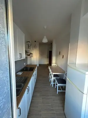 a kitchen with a table and a white refrigerator at Casa Susanna in Rome