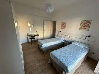 a hotel room with two beds and a desk at Casa Susanna in Rome