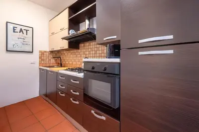a kitchen with brown cabinets and a stove in it at Number Five Apartment in Trastevere in Rome