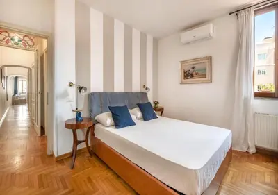a bedroom with a bed and a striped wall at Luxury in Rome Panoramic terrace Fontana di Trevi in Rome