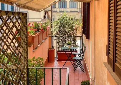 an apartment balcony with a table and potted plants at Luxury in Rome Panoramic terrace Fontana di Trevi in Rome