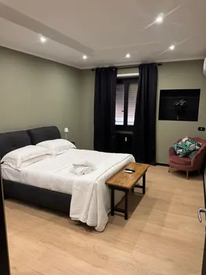 a bedroom with a large bed and a table at Marconi Suite & Charme in Rome