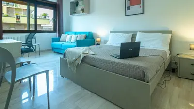 a bedroom with a bed with a laptop on it at Casa vacanza Appartamento Irnerio vicino la Metro in Rome