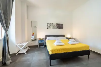 a bedroom with a yellow bed with towels on it at Angelina Domus Saint Peter's in Rome