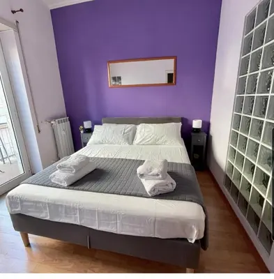 a bedroom with a bed with a purple wall at K-Vatican Apartment in Rome