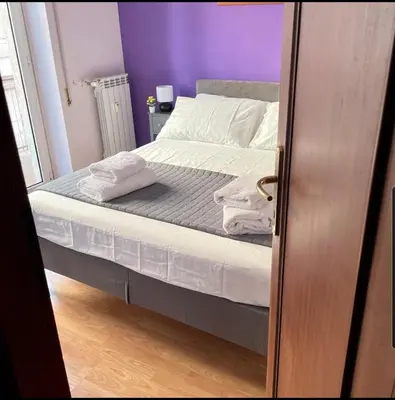 a bed with white sheets and pillows in a room at K-Vatican Apartment in Rome