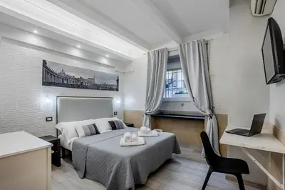 a hotel room with a bed and a desk and a television at Vatican Sweet Dreams Apartment in Rome