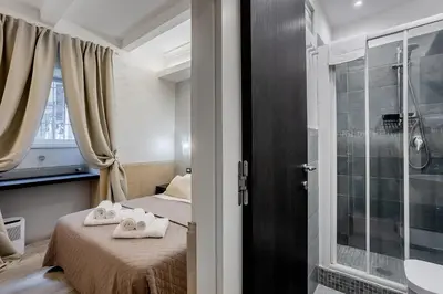 a small bedroom with a bed and a shower at Vatican Sweet Dreams Apartment in Rome