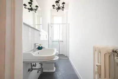 a white bathroom with a sink and a toilet at Exclusive View Rome I Residenza di Prestigio I 5 min metro Colosseo in Rome