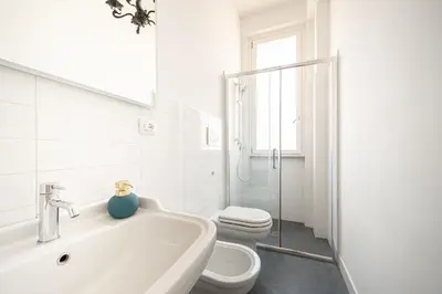 a white bathroom with a toilet and a sink at Exclusive View Rome I Residenza di Prestigio I 5 min metro Colosseo in Rome