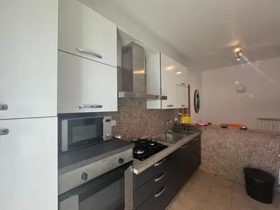 a kitchen with white cabinets and a stove top oven at Urban Oasis with Garden in Rome