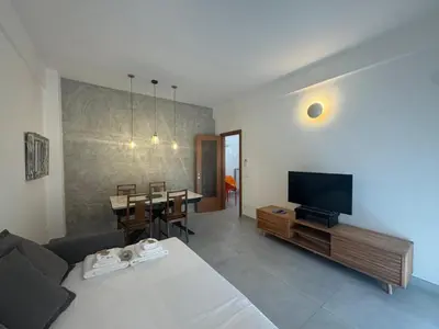 a living room with a bed and a tv and a table at Urban Oasis with Garden in Rome