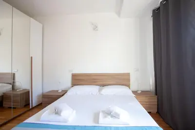 a bedroom with a large white bed with two towels at VI Domus - Vatican Museum Guest House - Roma in Rome