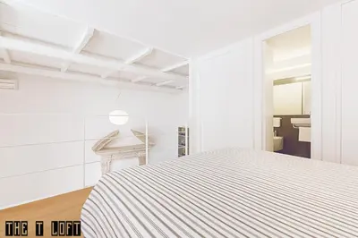 a white room with a bed and a bathroom at Trastevere Loft in Rome