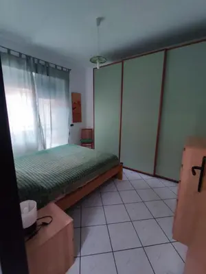 a bedroom with a green bed and a window at San Giovanni Apartment in Rome