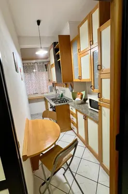 a small kitchen with a wooden table and chairs at San Giovanni Apartment in Rome