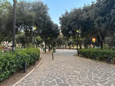 a cobblestone path in a park with trees and lights at Domus Albalonga in Rome