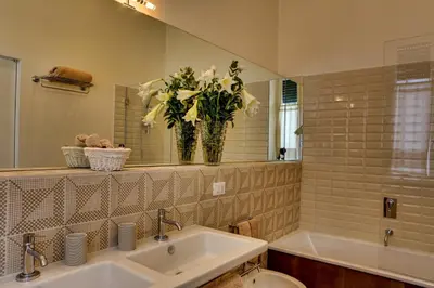 a bathroom with a sink and a vase of flowers at Casa Sotgiu Guest House in Rome