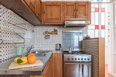 a kitchen with wooden cabinets and fruits on a cutting board at Casa di Cosimo - WelcomeToRhome in Rome