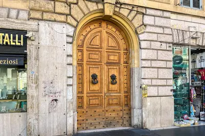 a large wooden door on the side of a building at La Finestra sulla Basilica in Rome