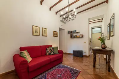a living room with a red couch and a table at Casa Fiori - WelcomeToRhome in Rome