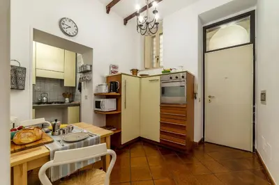 a kitchen with a refrigerator and a table with a sink at Casa Fiori - WelcomeToRhome in Rome