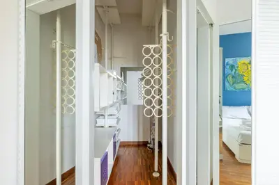 a room with white walls and a hallway with a bed at Nostromondo BIANCAMANO ATTIC - Stylish penthouse with private terrace- San Giovanni in Rome