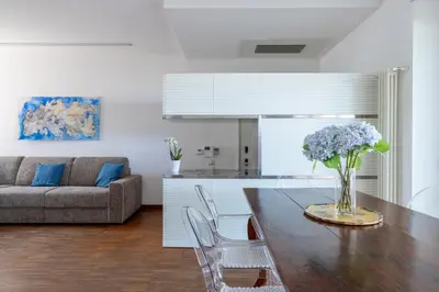 a living room with a table with a vase of flowers at Nostromondo BIANCAMANO ATTIC - Stylish penthouse with private terrace- San Giovanni in Rome