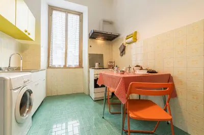 a kitchen with a table and a washing machine at Casa di Vigo - WelcomeToRhome in Rome