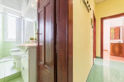 a bathroom with a wooden door and a sink at Casa di Vigo - WelcomeToRhome in Rome