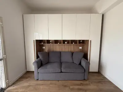 a living room with a gray couch in the corner at Sunflower House in Rome