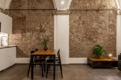 a dining room with a table and a brick wall at Casa Giulia - WelcomeToRhome in Rome