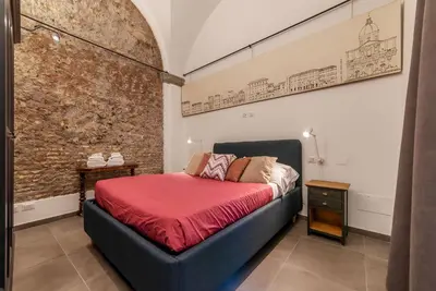 a bedroom with a bed and a brick wall at Casa Giulia - WelcomeToRhome in Rome