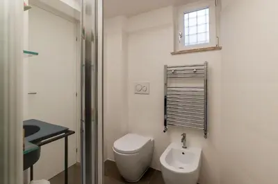 a white bathroom with a toilet and a sink at Casa Giulia - WelcomeToRhome in Rome