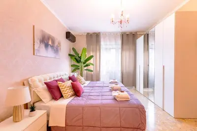 a bedroom with a large bed with colorful pillows at 7th Floor Terrace Stay - San Giovanni & Colosseum in Rome