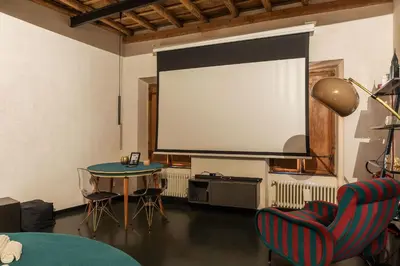 a room with a large screen and a table and chairs at GuestHost - Vintage-Modern Apartment Trastevere in Rome